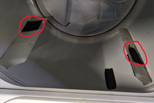 Inside of a clothes dryer with large patches of velcro (circled in red) attached to two fins